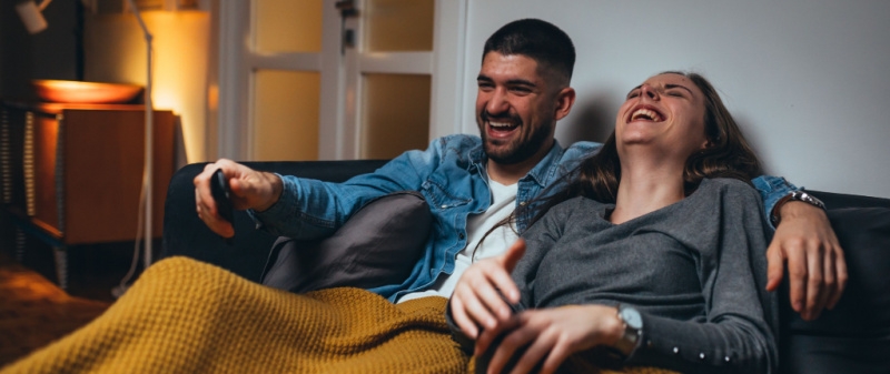 Couple on couch watching movie on TV